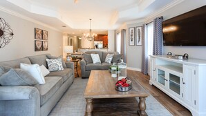 A living room with a sofa, coffee table, and TV. - Condo Serenity at Cabana Court 3 Bedroom Reunion (Kissimmee)