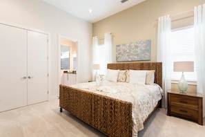 A bedroom with a large bed, a wardrobe, a bedside table with a lamp, and a painting on the wall.