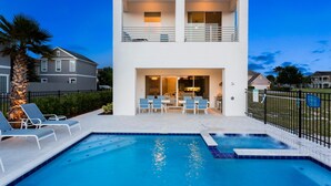 Une maison moderne à deux étages, dotée d’une piscine, d’un espace extérieur aménagé et d’une terrasse clôturée.