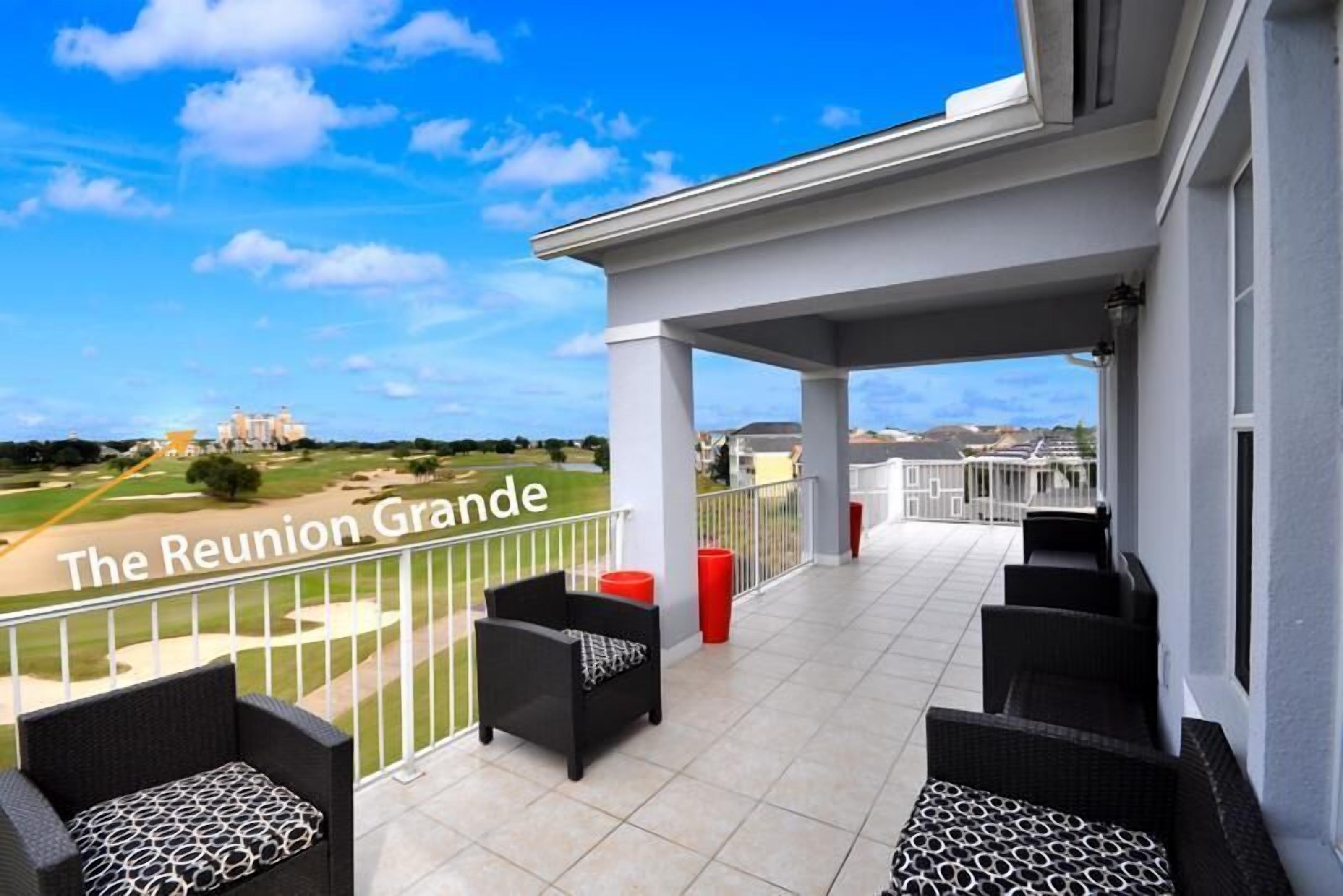A balcony with outdoor seating, a view of a golf course, and the text "The Reunion Grande".