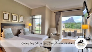 A luxury hotel room with a large bed, two bedside tables, a chair, a TV, and a view of the landscape.