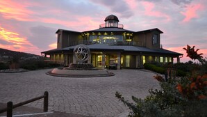A modern hotel with a circular central courtyard, a large decorative sculpture, and a dome-topped building.