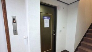 Corredor com uma porta marcada com o número 5 e um aviso indicando um quarto com vista.