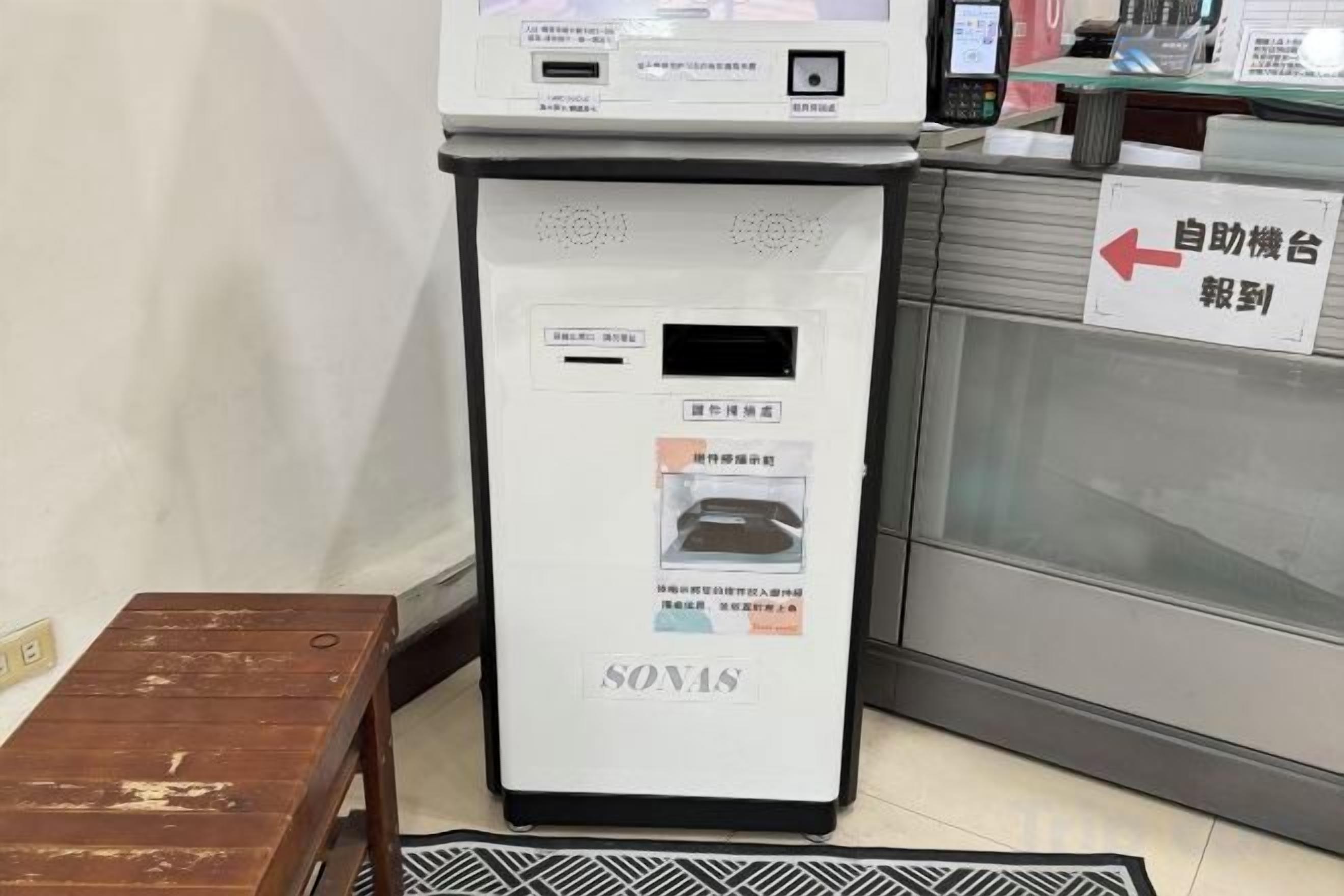 Una máquina expendedora de autoservicio con un cartel que indica su ubicación.