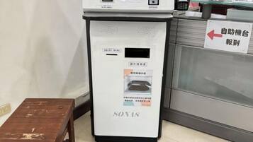 Una máquina expendedora de autoservicio con un cartel que indica su ubicación.