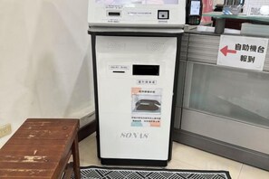 A self-service vending machine with a sign indicating its location. - Royalhotel (Hsinchu)
