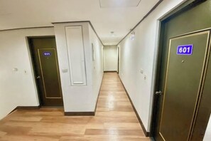 A hotel corridor with doors numbered 605 and 601, wooden flooring, and a plain wall. - Royalhotel (Hsinchu)
