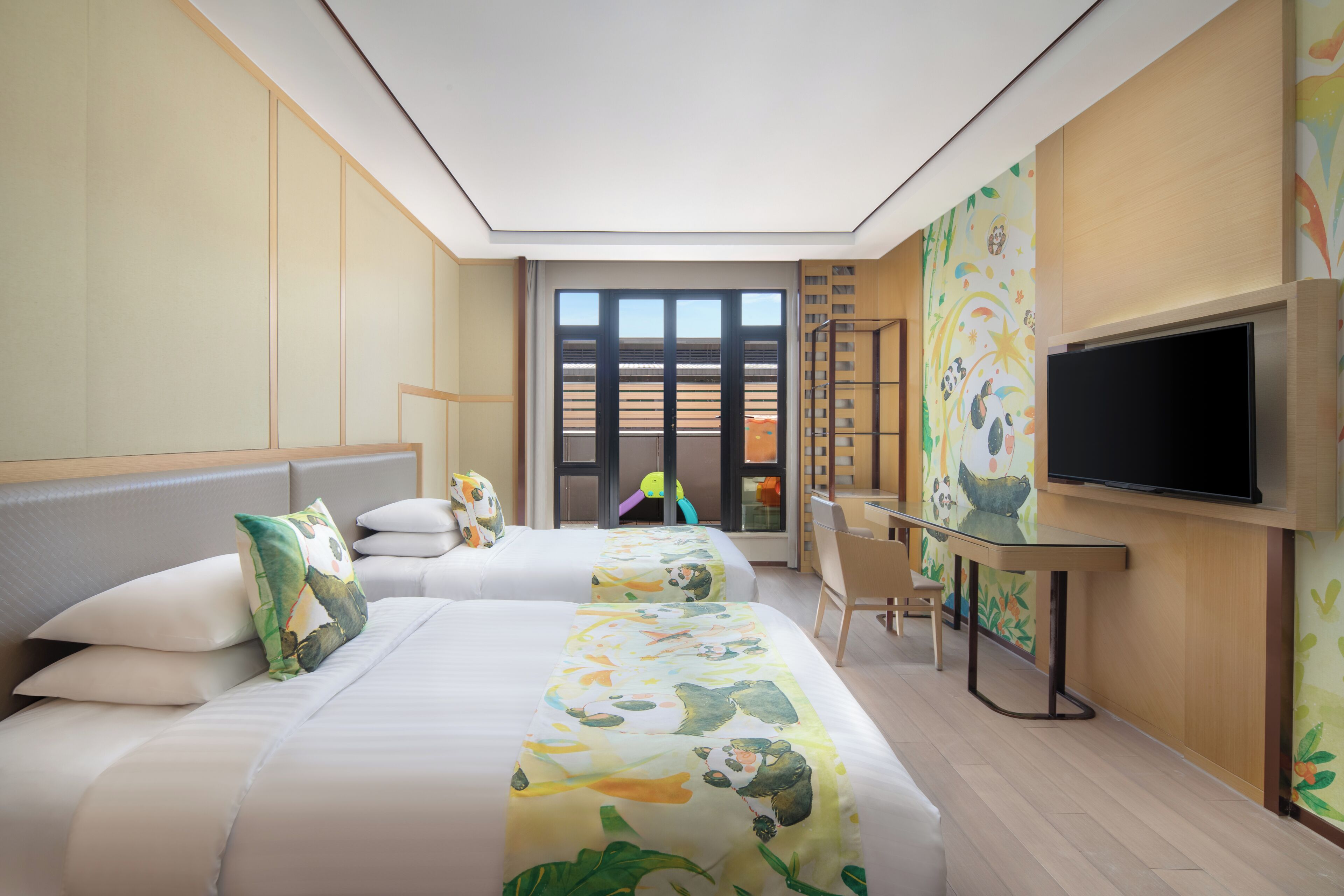 A hotel room with two beds, a desk, a chair, a television, and a large window.