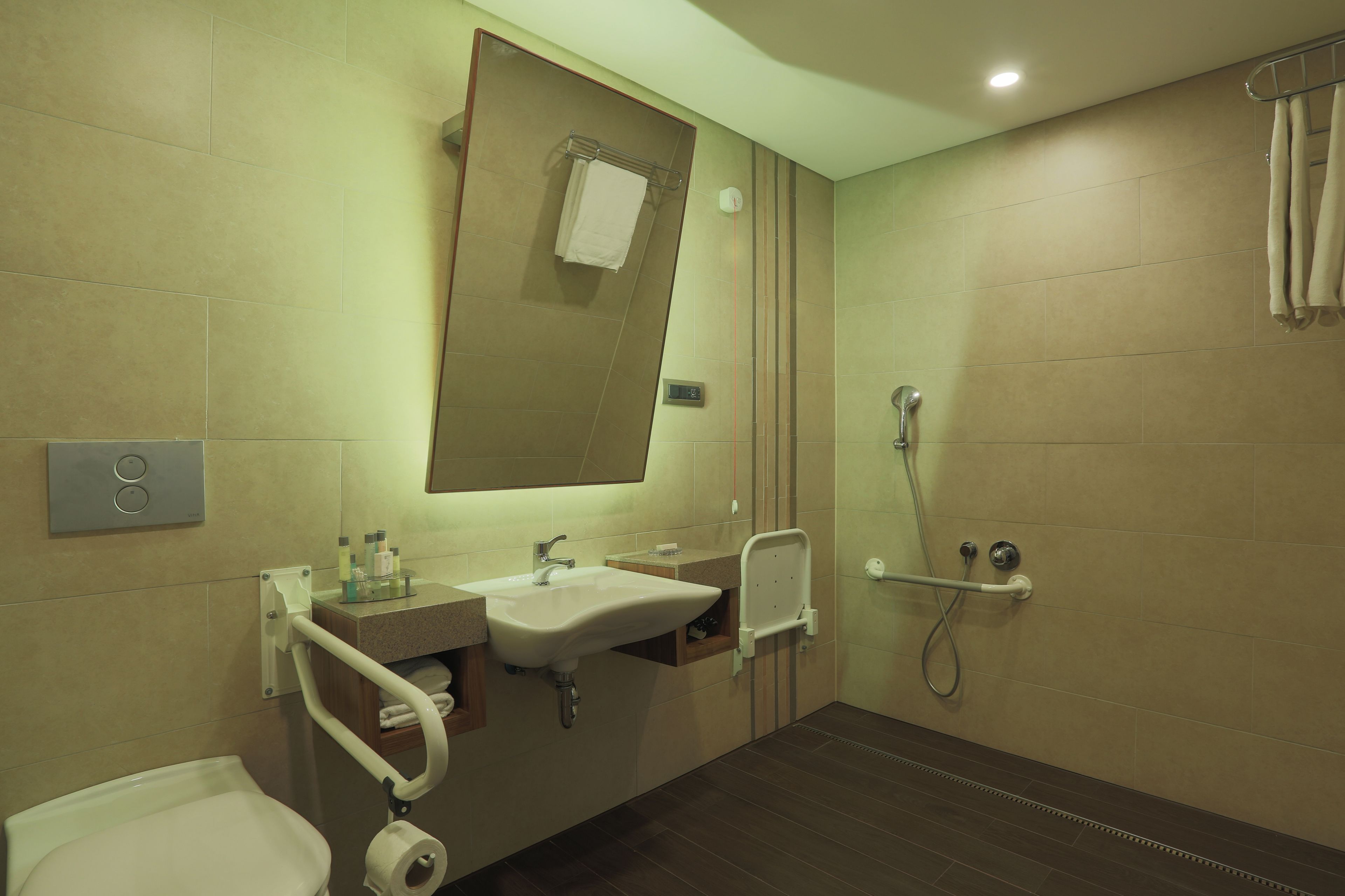 Une salle de bain moderne équipée d’un lavabo, d’un miroir, de toilettes et d’une douche.