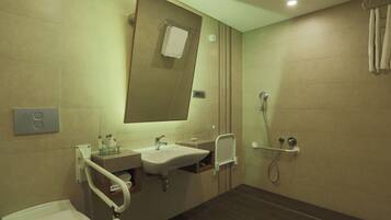 Une salle de bain moderne équipée d’un lavabo, d’un miroir, de toilettes et d’une douche.