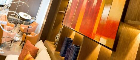 A modern interior with a large abstract painting, contemporary furniture, and a unique ceiling light fixture.