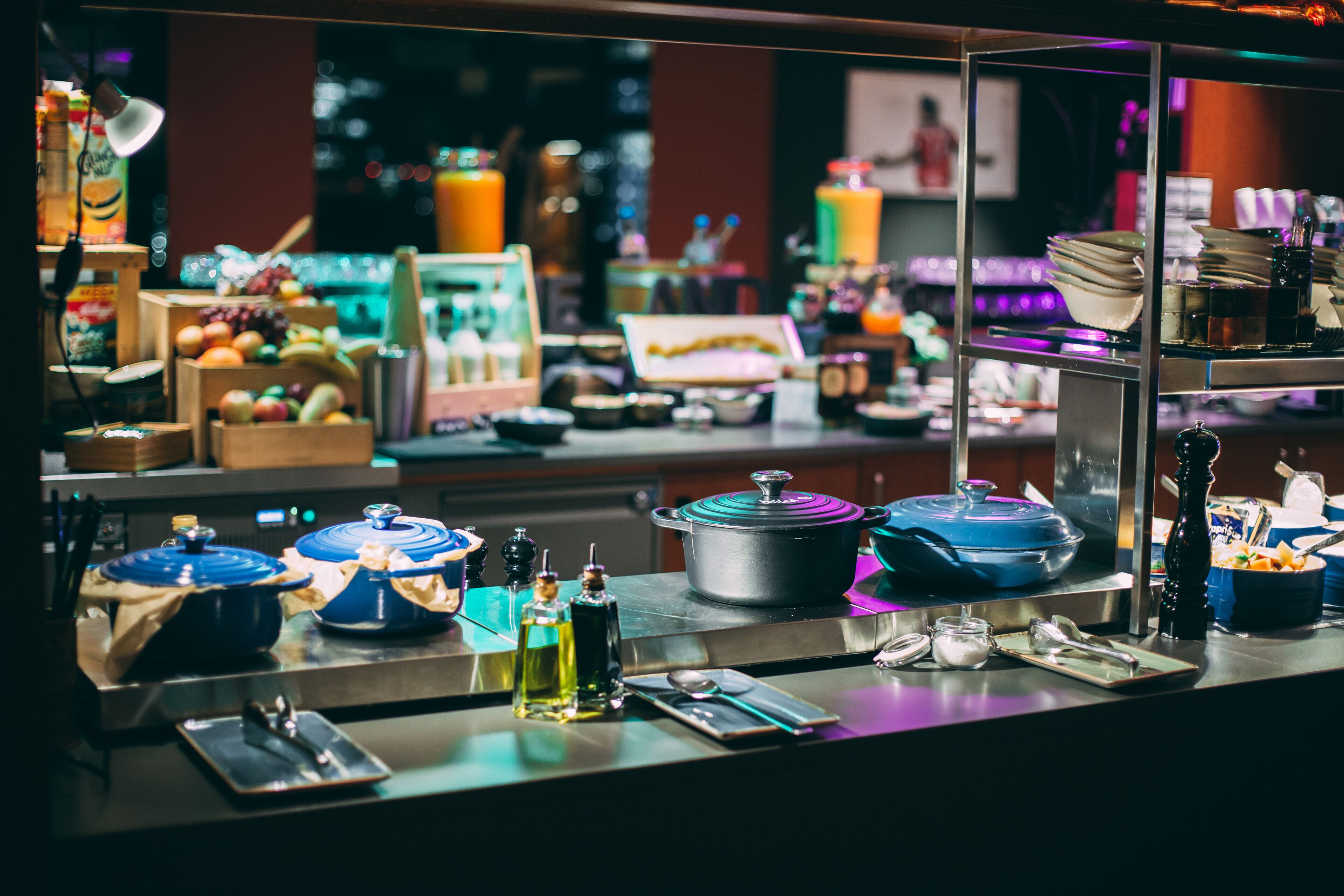 Mesa de buffet con diversos alimentos, utensilios de cocina y condimentos.