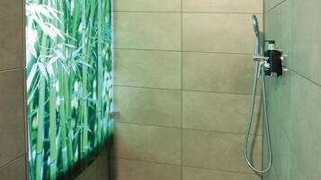 A shower with a bamboo-themed wall panel, a handheld showerhead, and a wall-mounted faucet.