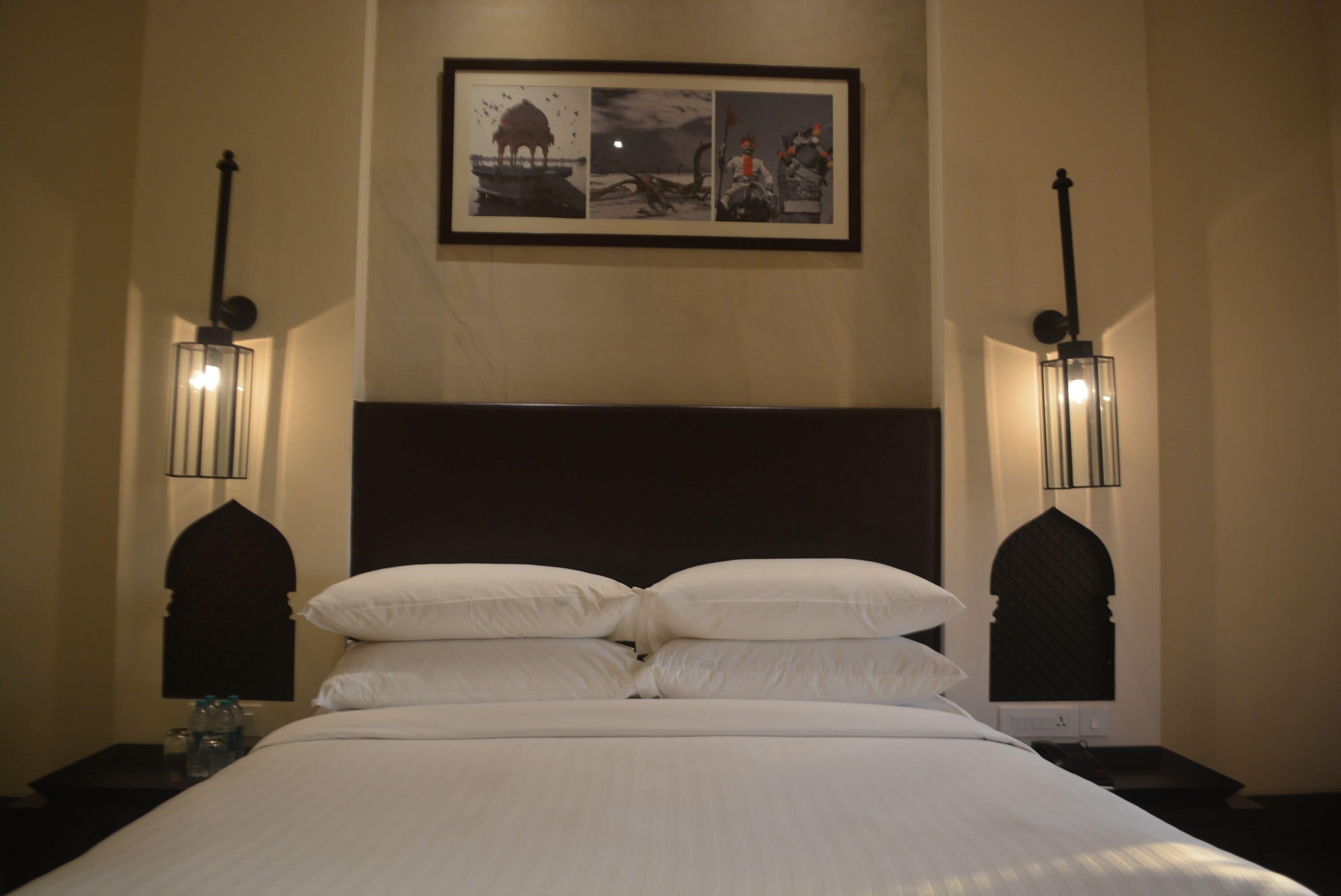 A neatly made bed with white linens and two nightstands on either side.