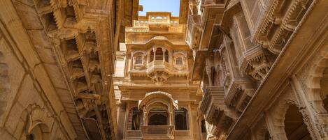 A narrow corridor with ornate architectural details and arched doorways.