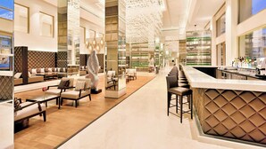 Een moderne hotellobby met een bar, zitgedeelte en een presentatie van flessen.