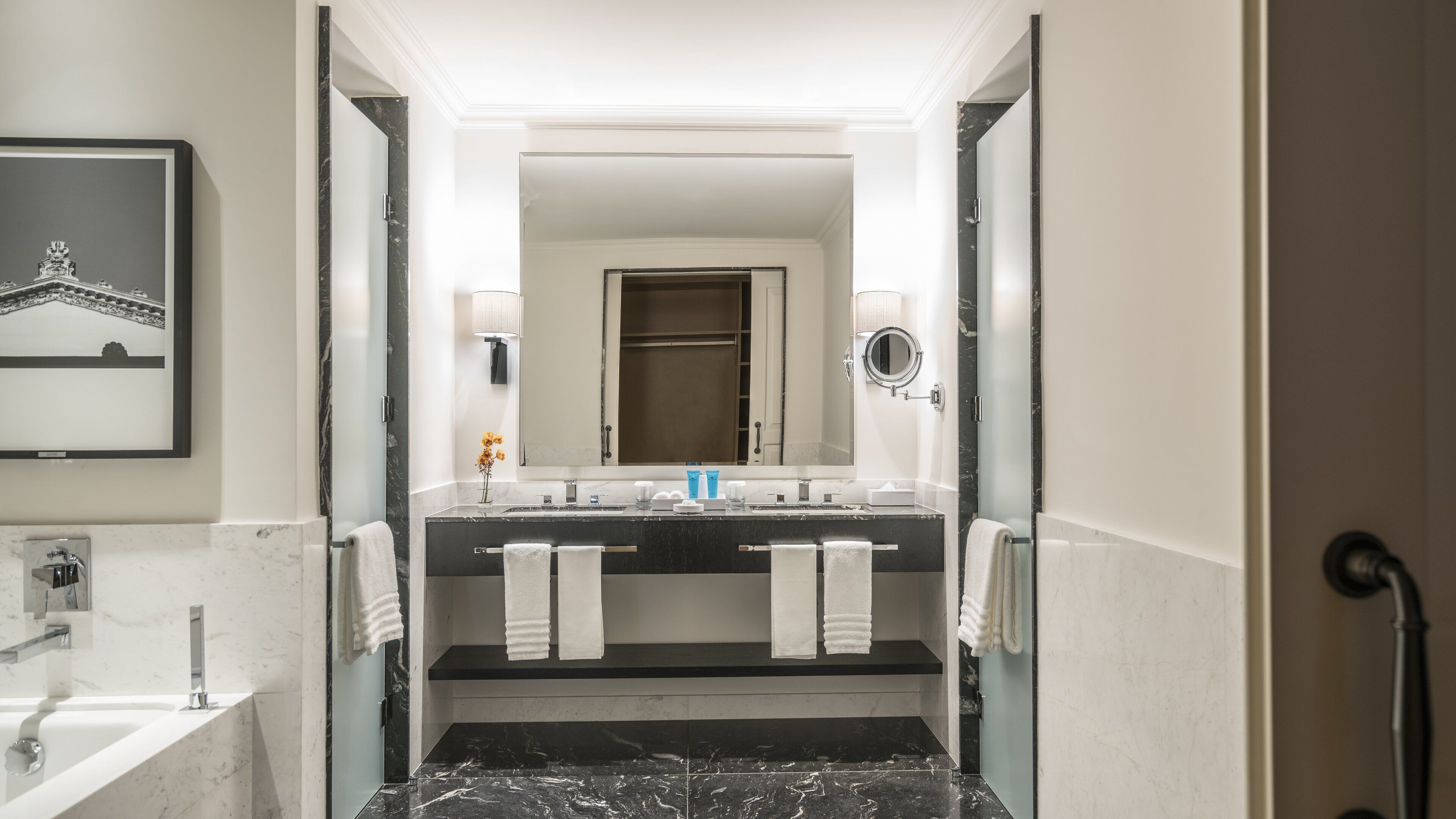Uma casa de banho moderna com um espelho grande, duas bacias e um chuveiro.