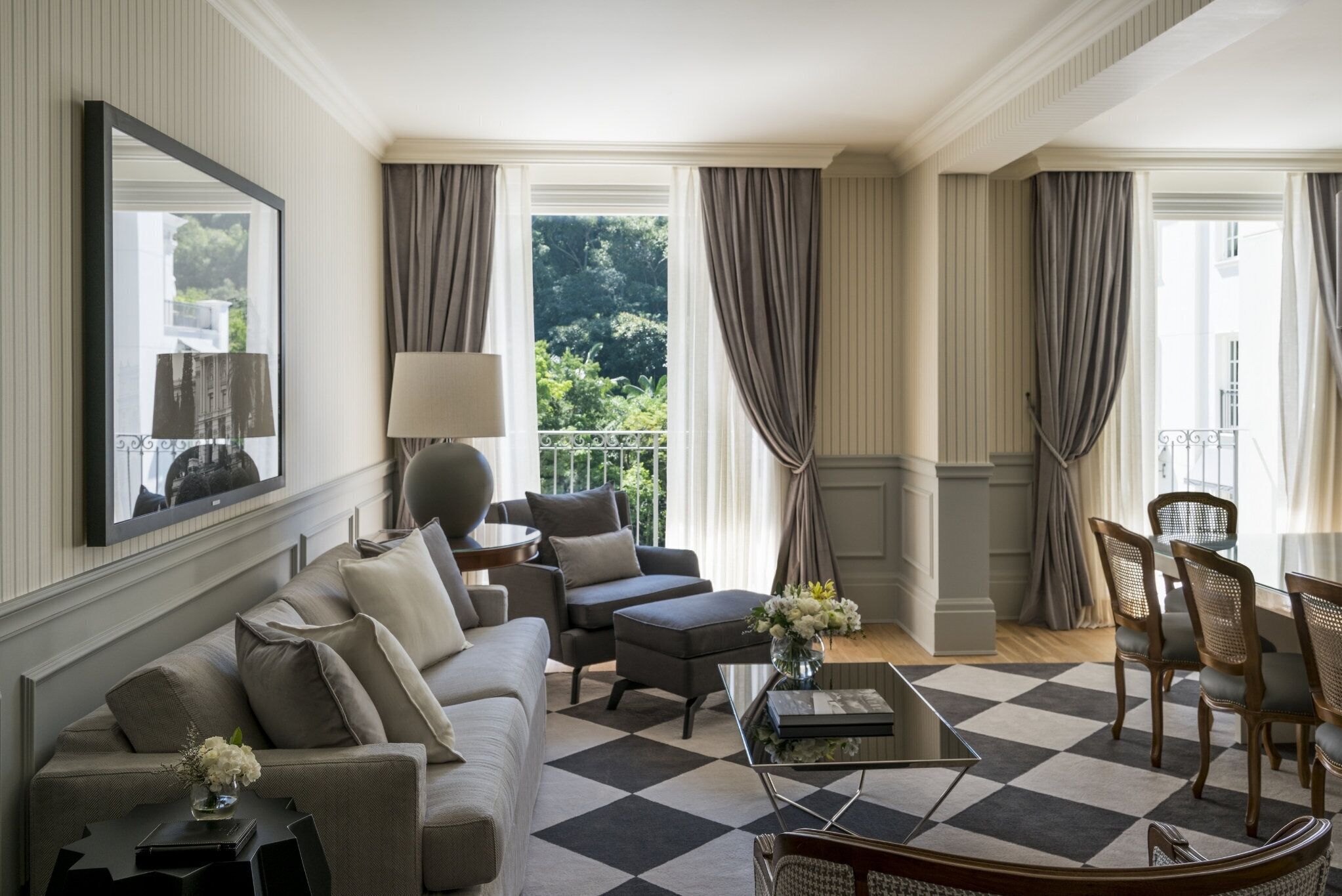 A spacious living room with a large sofa, a coffee table, and a dining area with chairs.