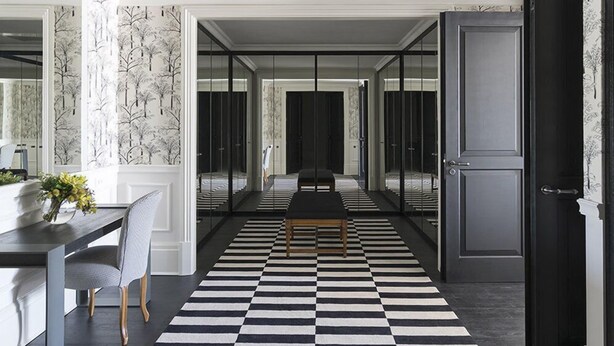 A modern interior with a checkered floor, a dining area with a table and chairs, and a hallway leading to a room with a door. - Palacio Tangara, Oetker Hotels (São Paulo)