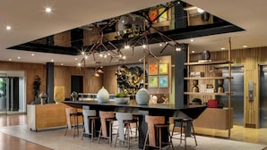 A modern kitchen with a central island, bar stools, pendant lighting, and a decorative ceiling. - The Elmore Hotel, DFW Southlake, a Tribute Portfolio Hotel (Southlake)