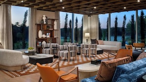 A spacious living room with a large window, a fireplace, and a variety of seating options. - The Elmore Hotel, DFW Southlake, a Tribute Portfolio Hotel (Southlake)