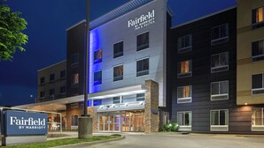 A multi-story hotel with a modern facade, a sign indicating it's a Marriott property, and a well-lit entrance.