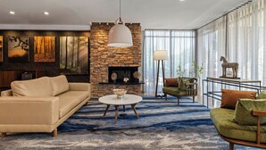 A modern living room with a stone wall, a sofa, a round coffee table, and a fireplace.