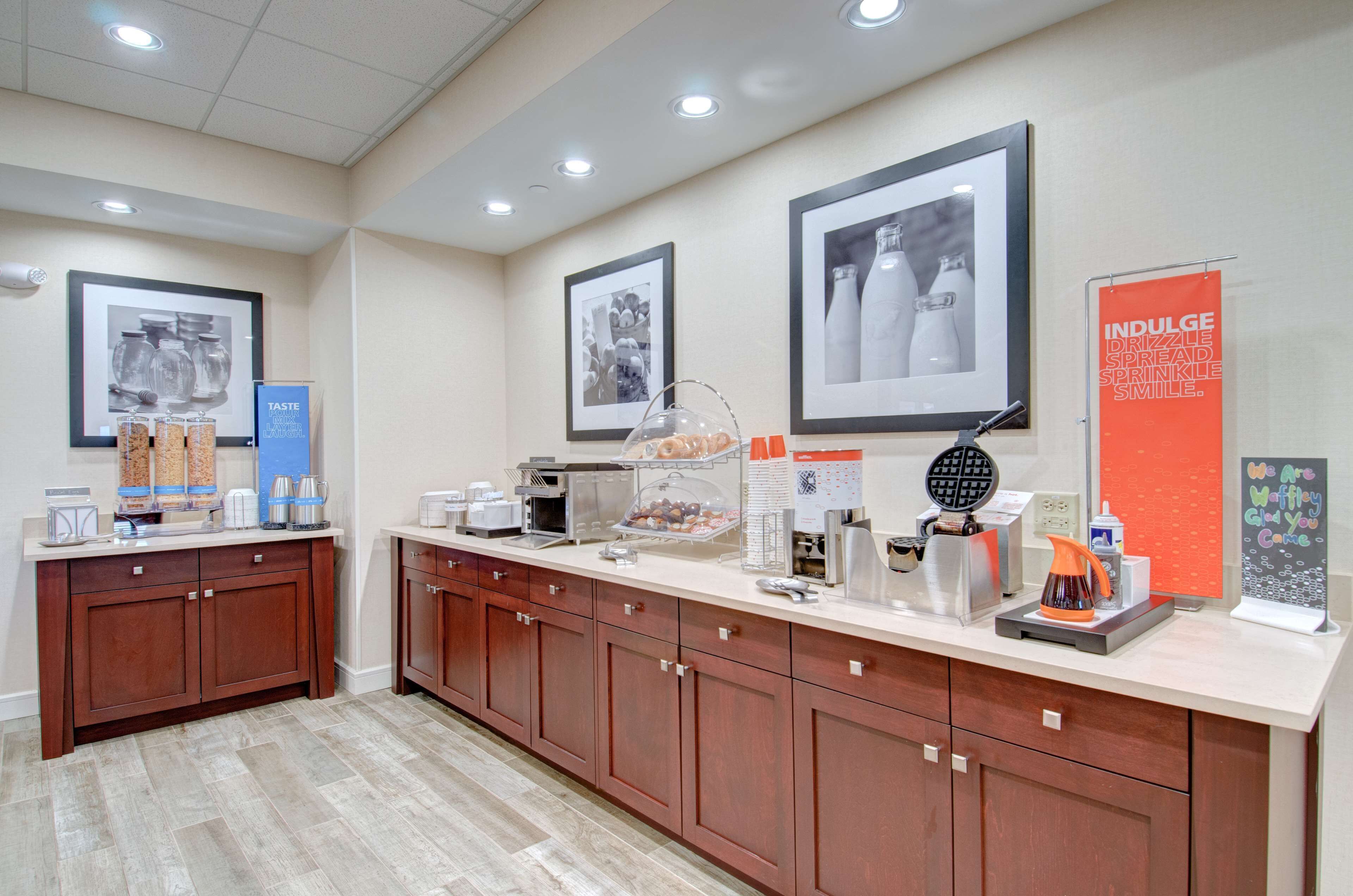 A hotel reception area with a counter, coffee machines, and a beverage dispenser.