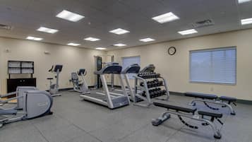 Un gimnasio con cintas de correr, elípticas y pesas sueltas.
