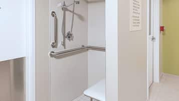A shower area with grab bars and a bench.