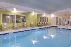 Una piscina interior con sillones de descanso y puesto de socorrista.