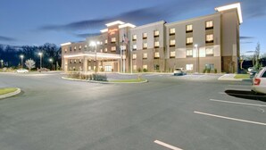 Un hôtel moderne doté d’un hall d’entrée bien éclairé, de plusieurs étages et d’un parking.