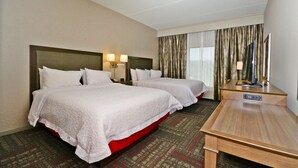 A hotel room with two beds, a desk, and a television. - Hampton Inn Pulaski (Pulaski)