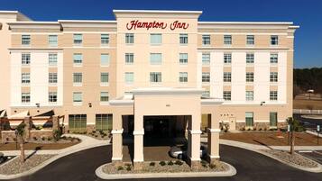 Un hotel Hampton Inn amb una façana moderna, diversos pisos i una entrada central.