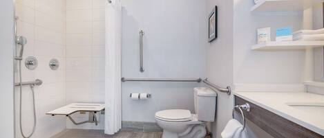 Een moderne badkamer met douche, toilet en wastafel.