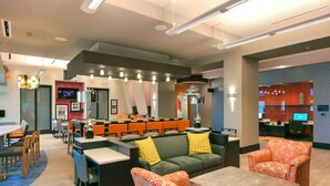 A modern hotel lobby with a seating area, a bar, and a reception desk. - Hampton Inn Lumberton (Lumberton)