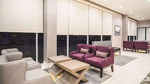 Een moderne woonkamer met een bank, fauteuils en een salontafel.
