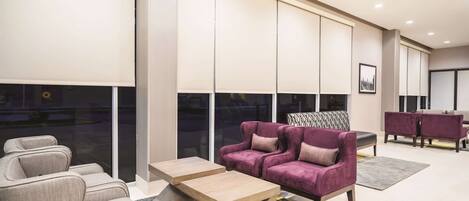 A modern living room with a sofa, armchairs, and a coffee table.