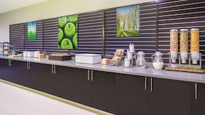 Een moderne keuken met een lange aanrecht, diverse keukenapparatuur en opbergkasten.