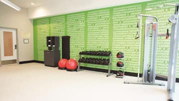 A gym with exercise equipment, including dumbbells and a medicine ball.
