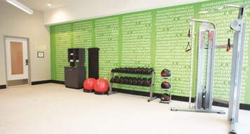 A gym with exercise equipment, including dumbbells and a medicine ball.