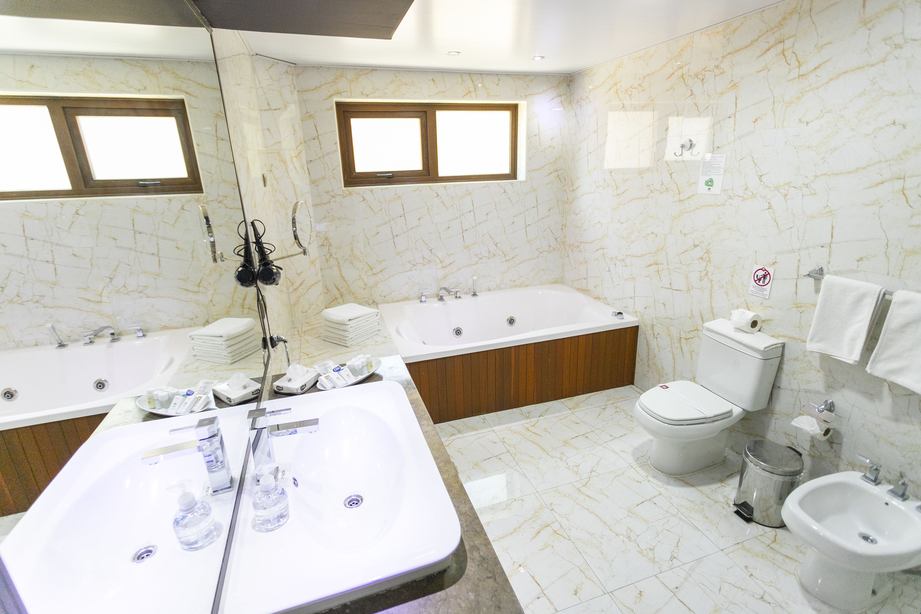 A modern bathroom with a large bathtub, a separate shower area, a toilet, and a sink.