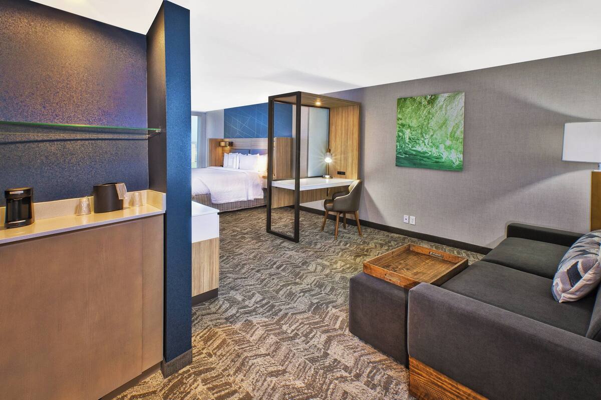 Une chambre d’hôtel comprenant un lit, un bureau et un coin salon.