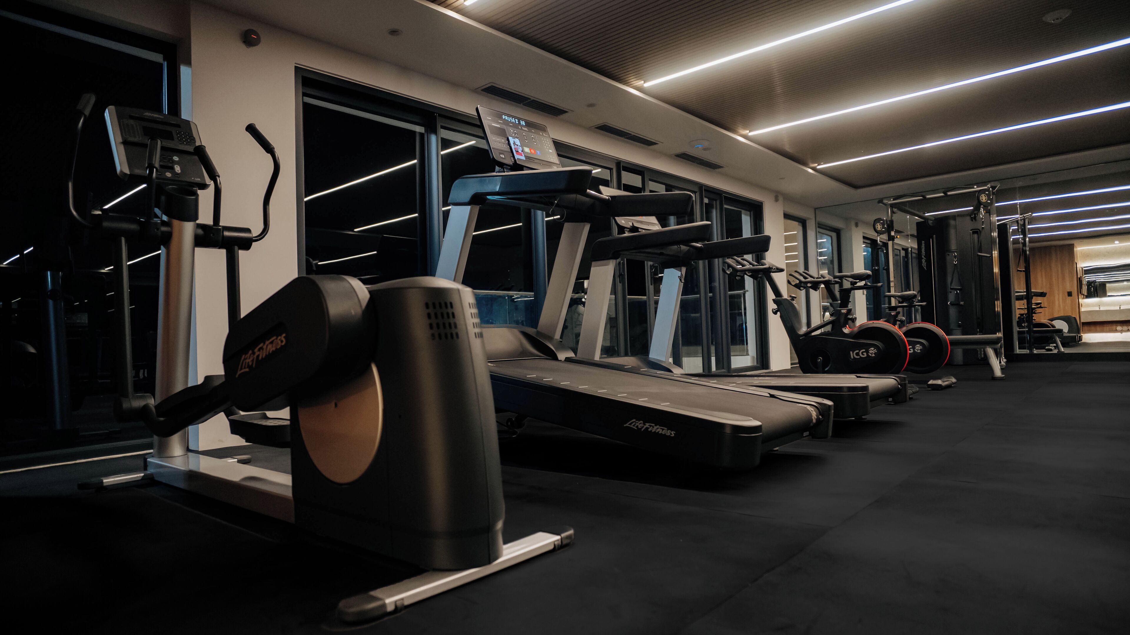 A gym with treadmills, elliptical machines, and weight equipment.