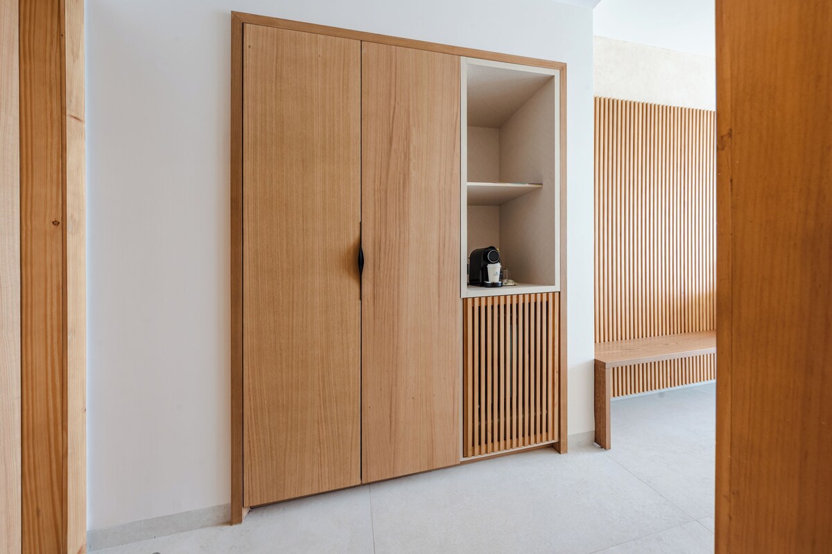 A wooden wardrobe with a built-in shelf and a bench.