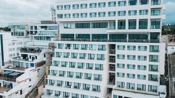 A multi-story hotel with a rooftop pool area, including sun loungers and umbrellas.