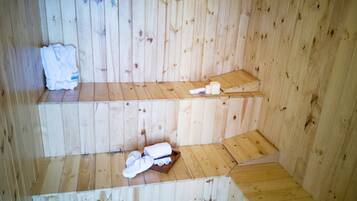 Relax in a serene sauna with tiered seating and amenities at your fingertips.