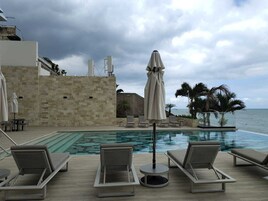 Una piscina al aire libre, sombrillas, tumbonas