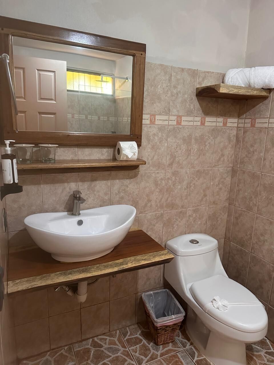 Une salle de bain avec un lavabo, des toilettes et un miroir.