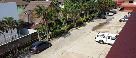 A residential street with parked cars and houses.